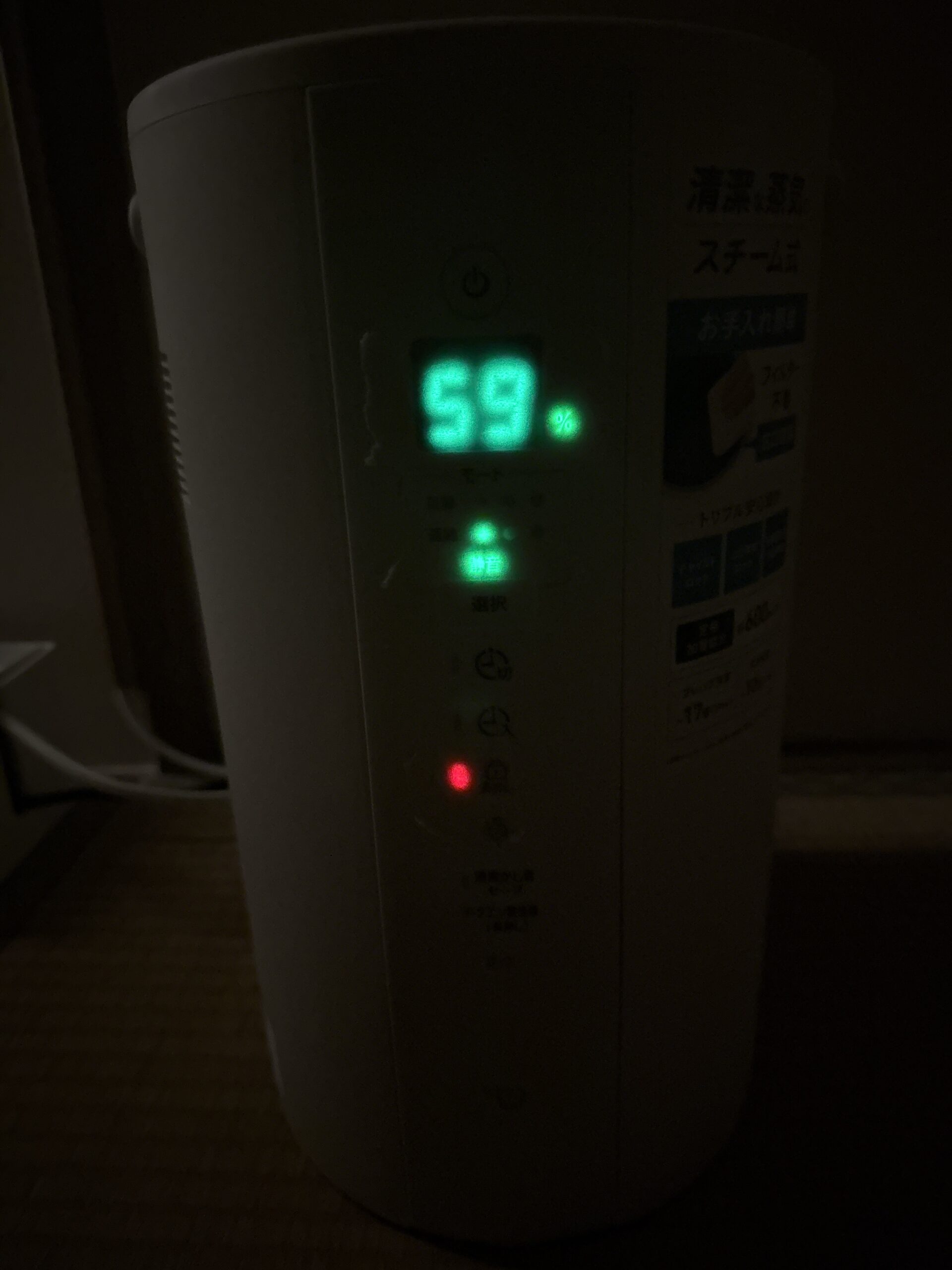 暗い寝室で撮影した象印スチーム式加湿器。湿度表示とランプはマスキングテープ越しに柔らかい光になり、寝室でも気になりにくい明るさになっている状態。