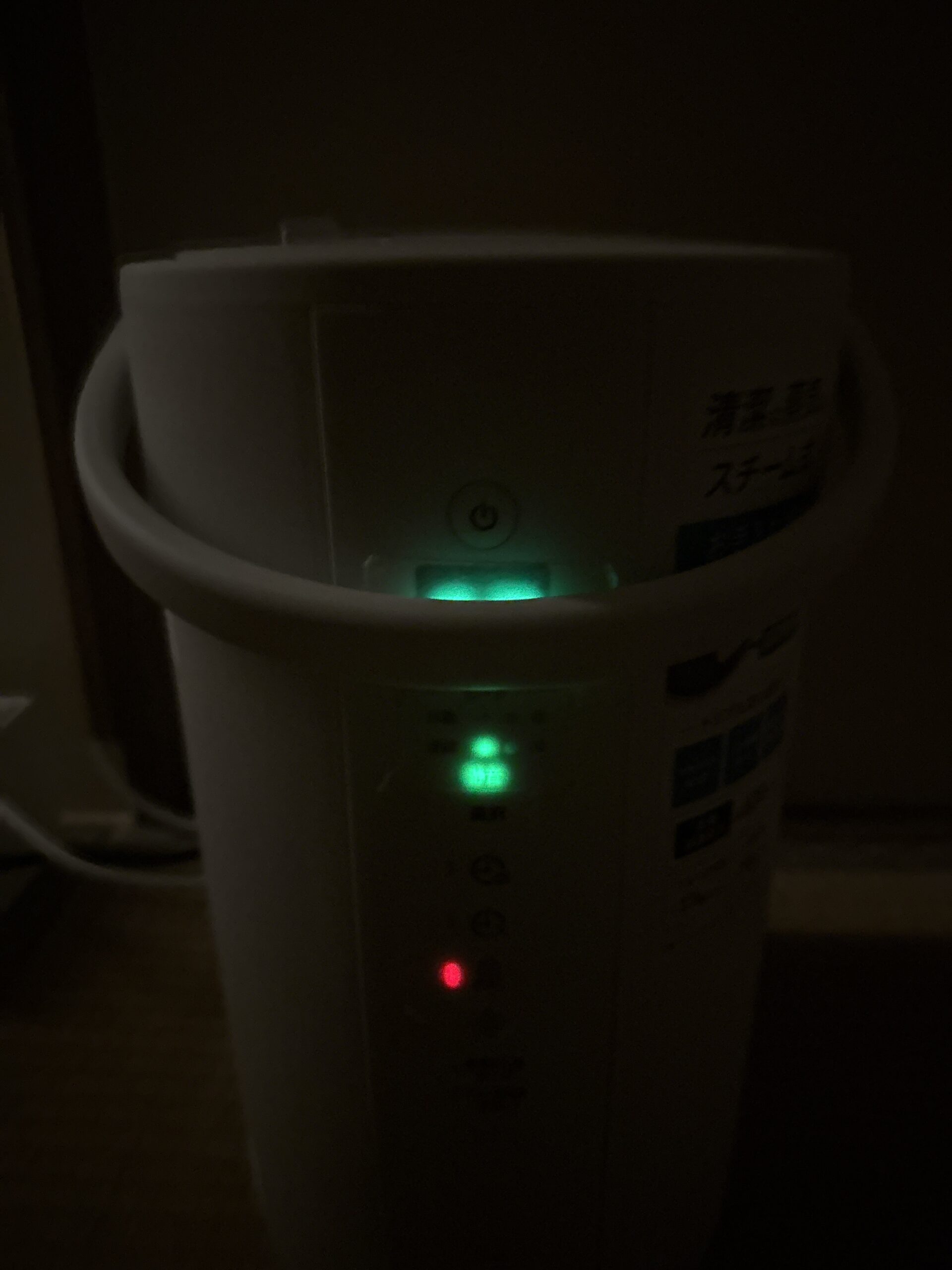 暗い寝室で撮影した象印スチーム式加湿器。湿度表示とランプはマスキングテープ越しに柔らかい光になり、寝室でも気になりにくい明るさになっている状態。