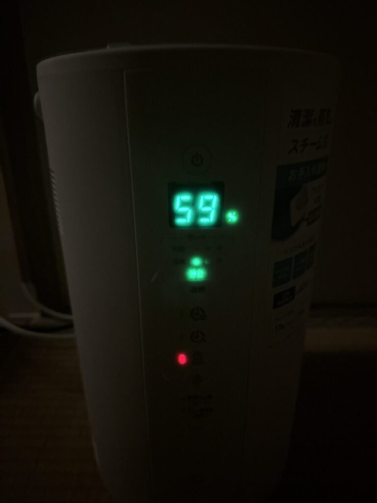 象印スチーム式加湿器の湿度表示“59%”がマスキングテープなしで明るく発光している様子。暗い寝室で数字部分が強く目立つ光量が確認できる写真。